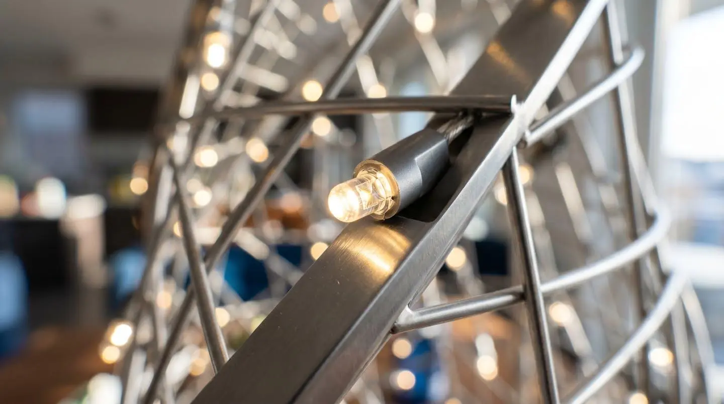 Gros plan sur une guirlande lumineuse LED moderne fixée sur une structure métallique contemporaine avec bokeh lumineux en arrière-plan